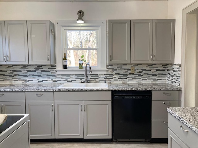 kitchen with dishwasher, sink, decorative backsplash, gray cabinets, and light stone counters