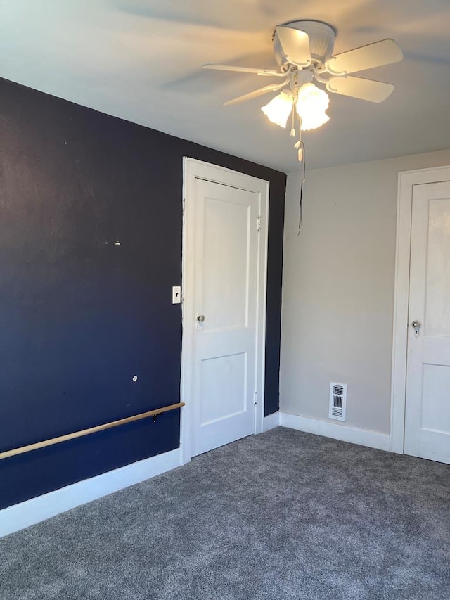 empty room with ceiling fan and carpet