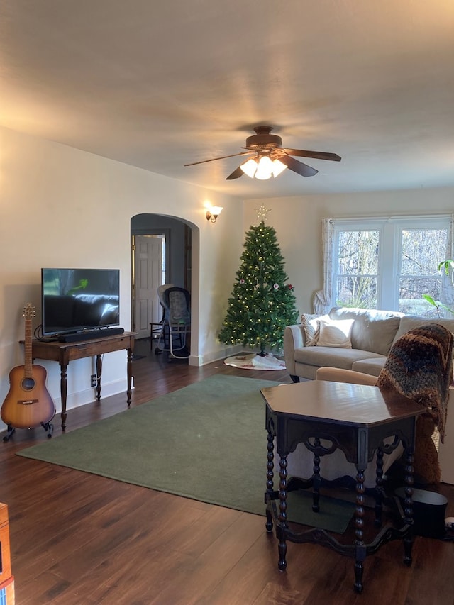 living room with ceiling fan and dark wood-type flooring