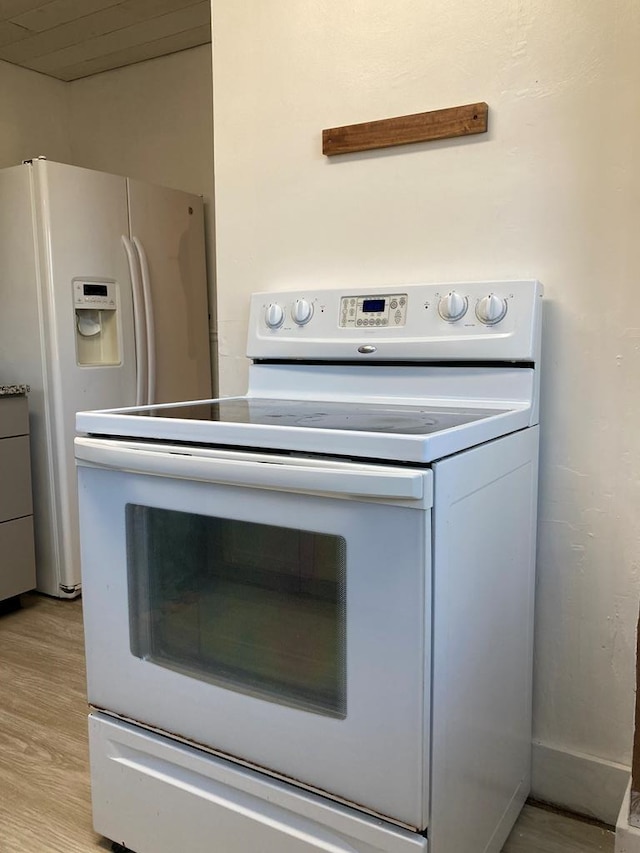 interior space with white appliances and light hardwood / wood-style floors