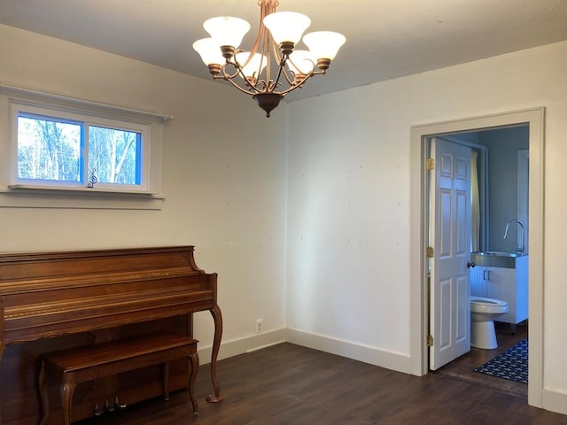 misc room with dark wood-type flooring and an inviting chandelier