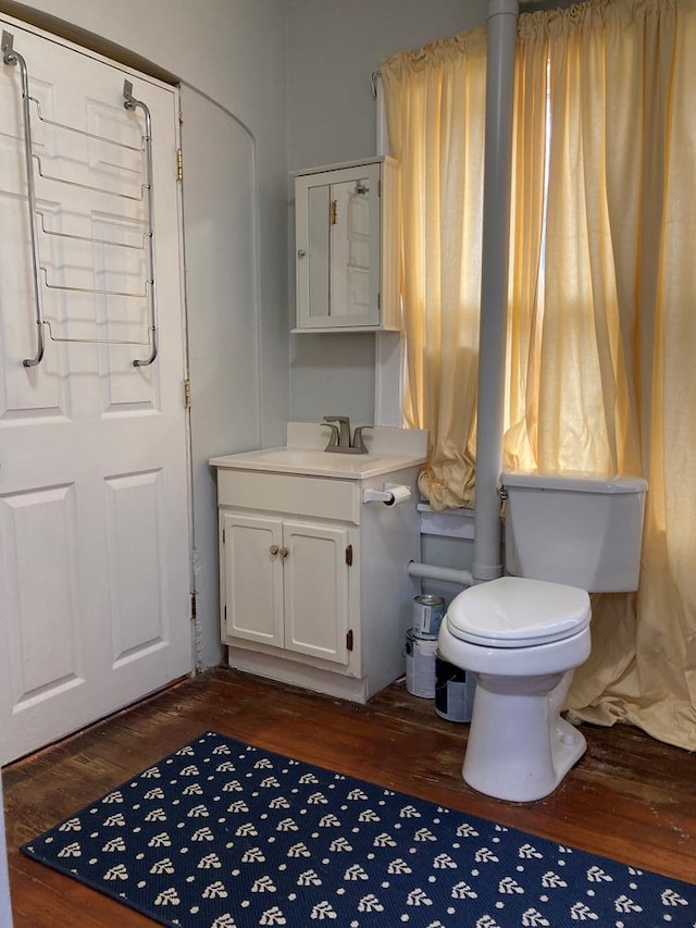 bathroom with hardwood / wood-style flooring, vanity, and toilet