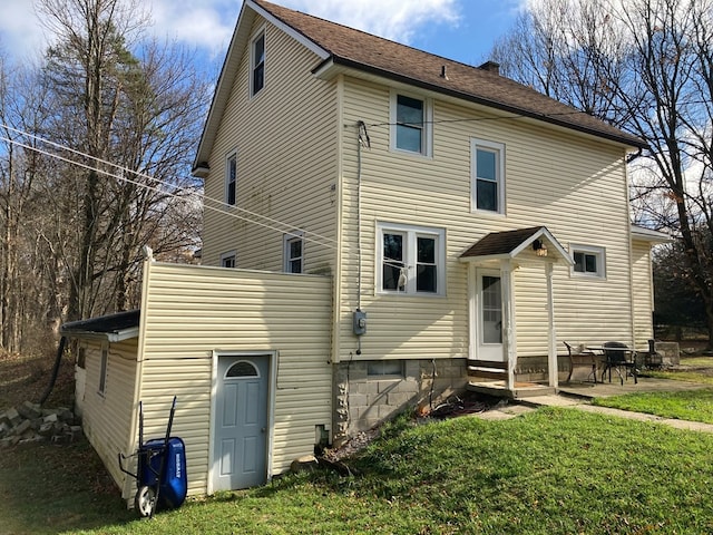 back of house featuring a lawn