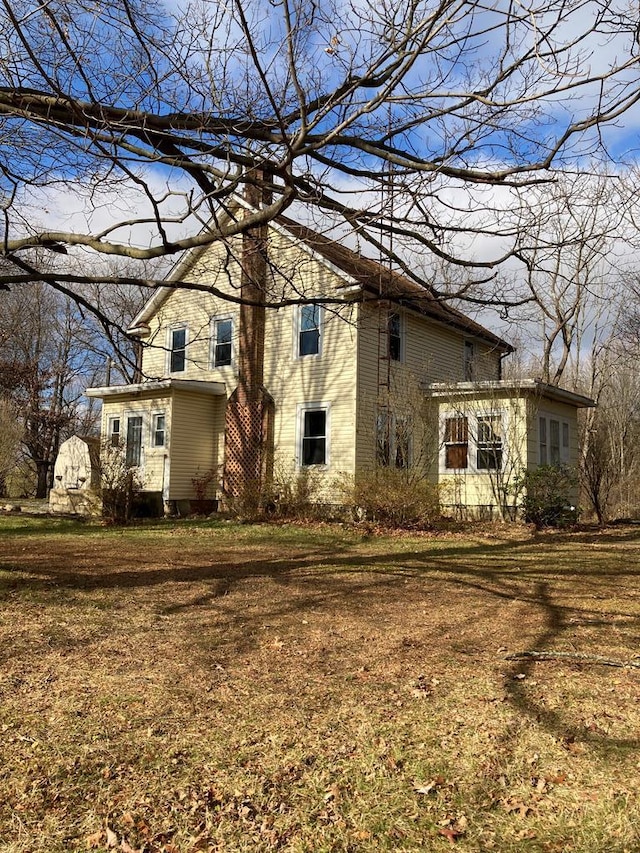 back of property featuring a lawn