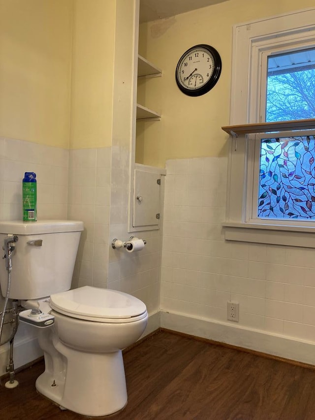 bathroom featuring built in shelves, wood-type flooring, tile walls, and toilet