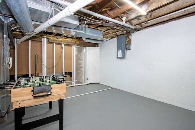 unfinished basement featuring concrete block wall and electric panel