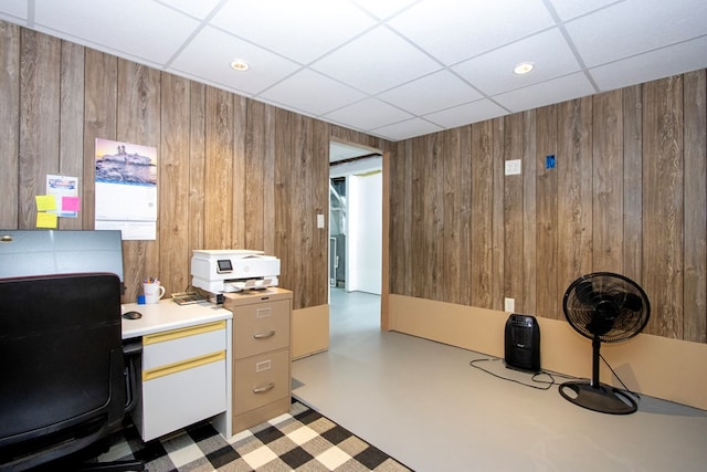 office space with wood walls and a drop ceiling