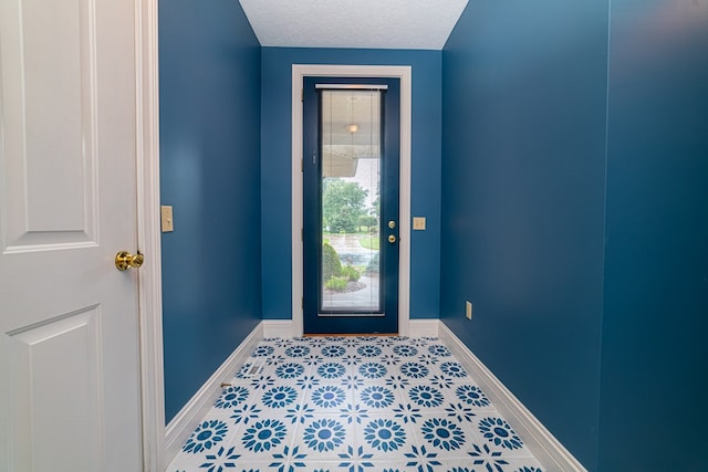 doorway to outside featuring a textured ceiling