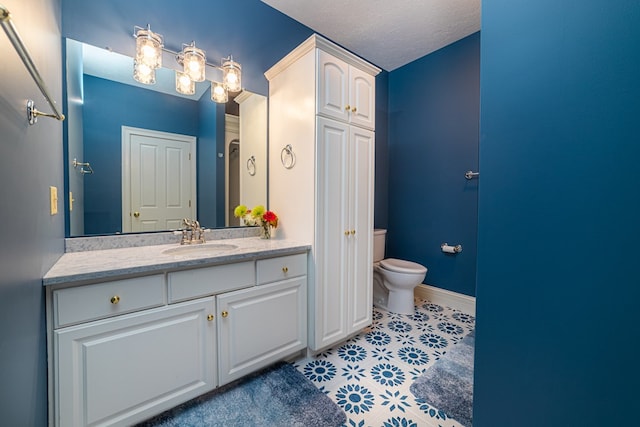 bathroom featuring vanity, toilet, and a textured ceiling