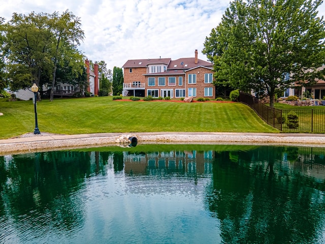 rear view of property with a water view and a yard