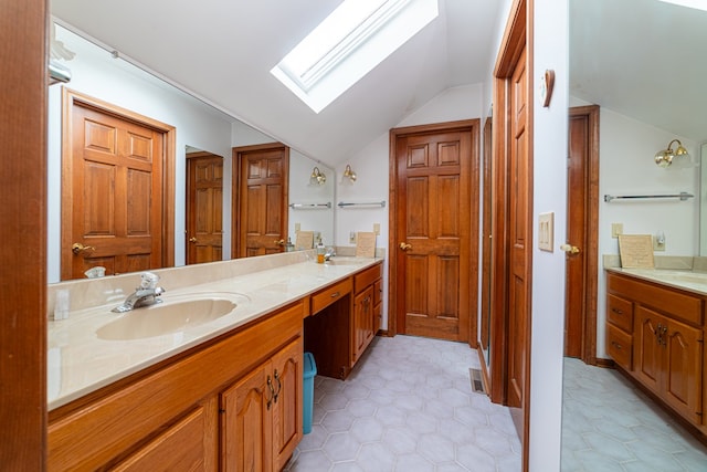 bathroom featuring tile patterned flooring, vanity, and lofted ceiling with skylight