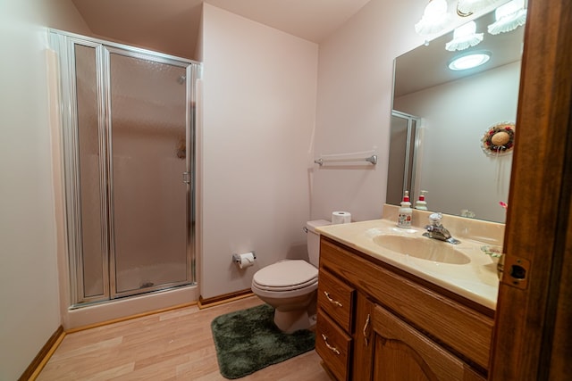 bathroom with hardwood / wood-style floors, vanity, toilet, and a shower with shower door