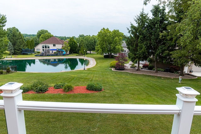 view of pool with a yard and a water view