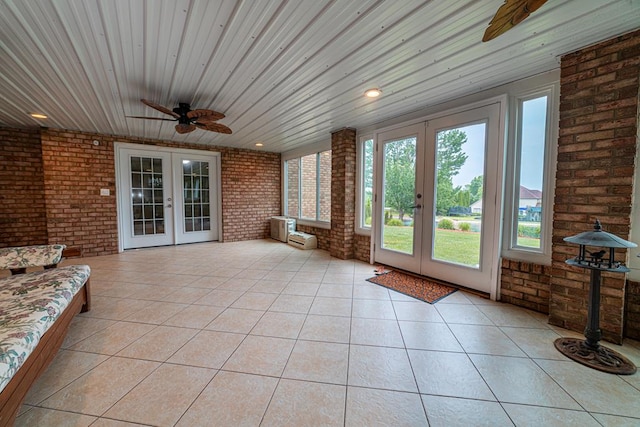 unfurnished sunroom with ceiling fan and french doors