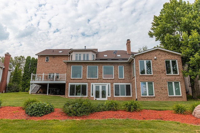 rear view of house with a yard and a deck