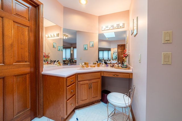 bathroom featuring tile patterned flooring, vanity, and a skylight