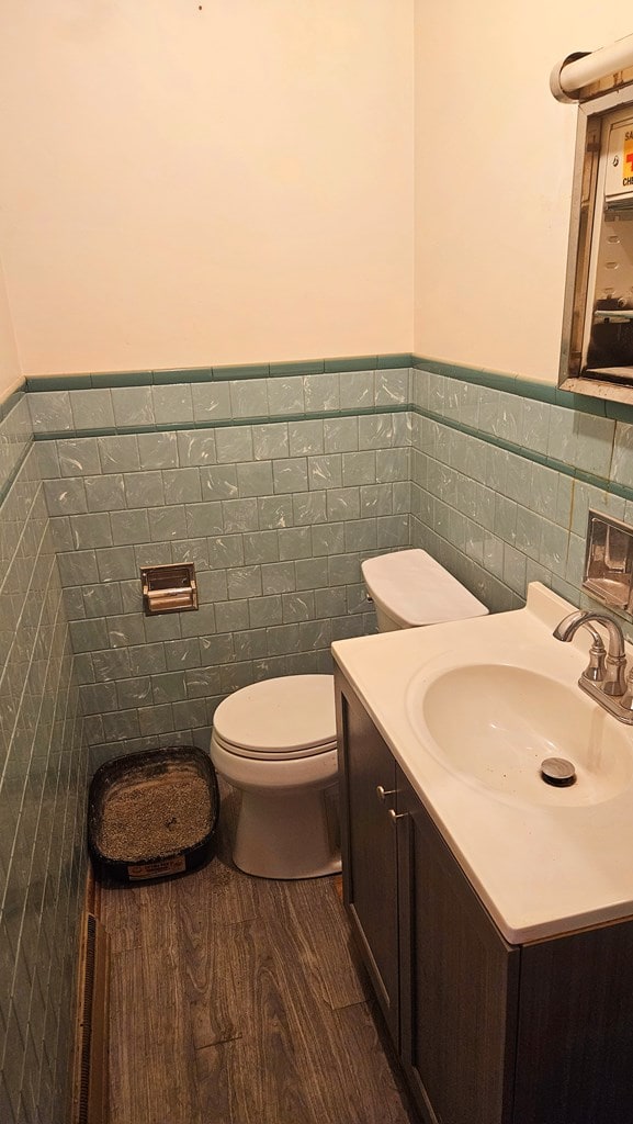 bathroom with vanity, toilet, hardwood / wood-style floors, and tile walls