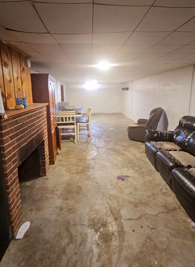 basement featuring a drop ceiling and a fireplace