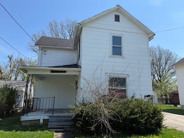 back of house featuring a shingled roof and a porch