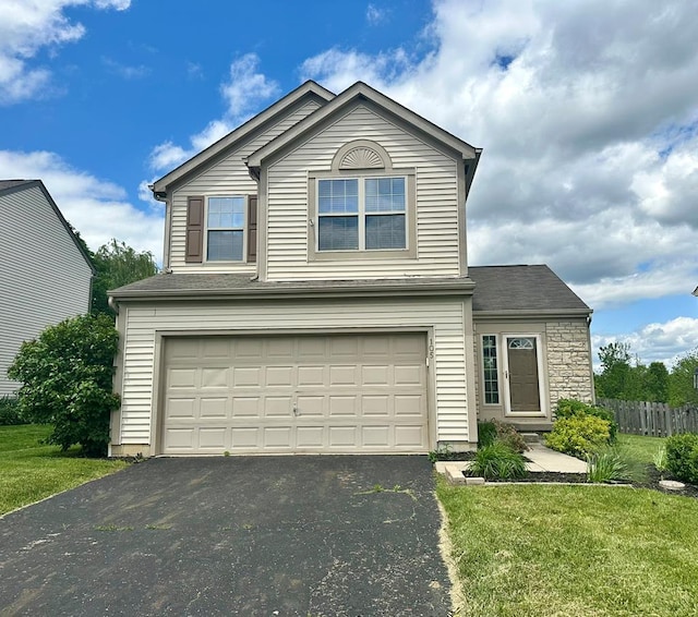 105 Purple Finch Loop, Pataskala, OH 43062 - traditional-style home with stone siding, aphalt driveway, a front lawn, and an attached garage