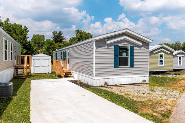 view of home's exterior featuring a shed, a yard, and central AC