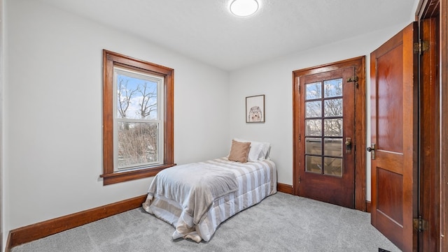 bedroom with light colored carpet and multiple windows