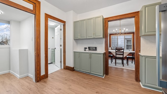 kitchen with pendant lighting, light hardwood / wood-style flooring, and a chandelier