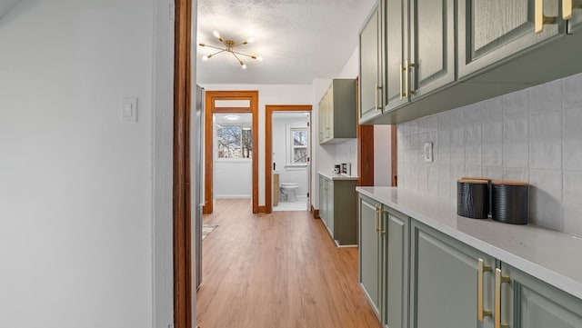 kitchen featuring backsplash, light hardwood / wood-style flooring, and green cabinets