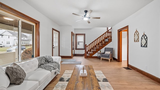 living room featuring ceiling fan and light hardwood / wood-style flooring