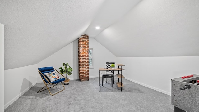 home office with lofted ceiling, light carpet, and a textured ceiling