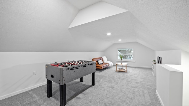 recreation room featuring lofted ceiling, carpet flooring, and a textured ceiling