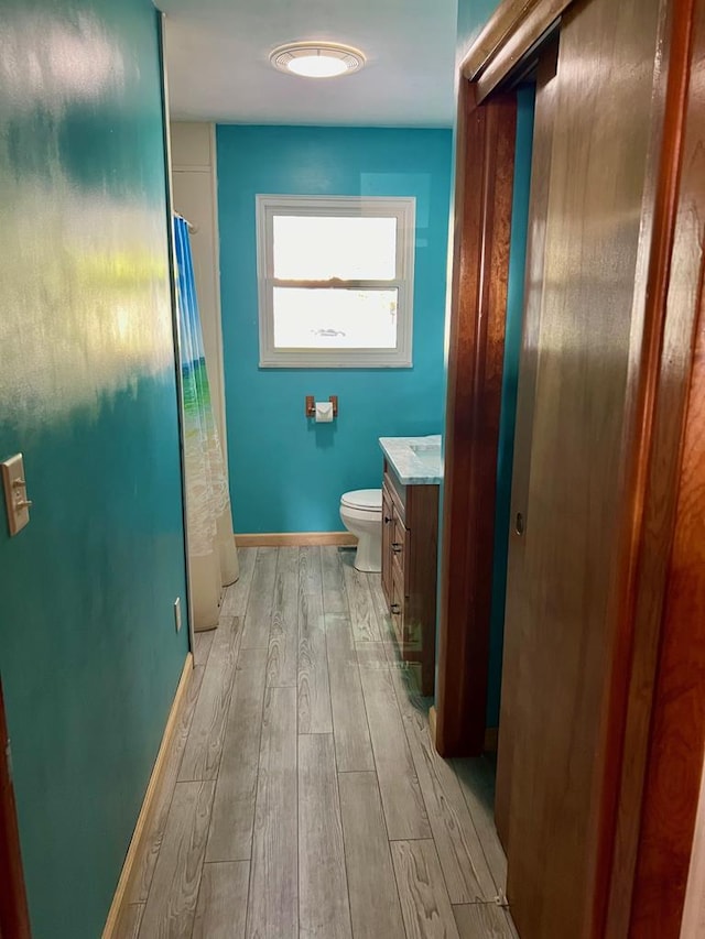 bathroom with hardwood / wood-style floors, vanity, and toilet