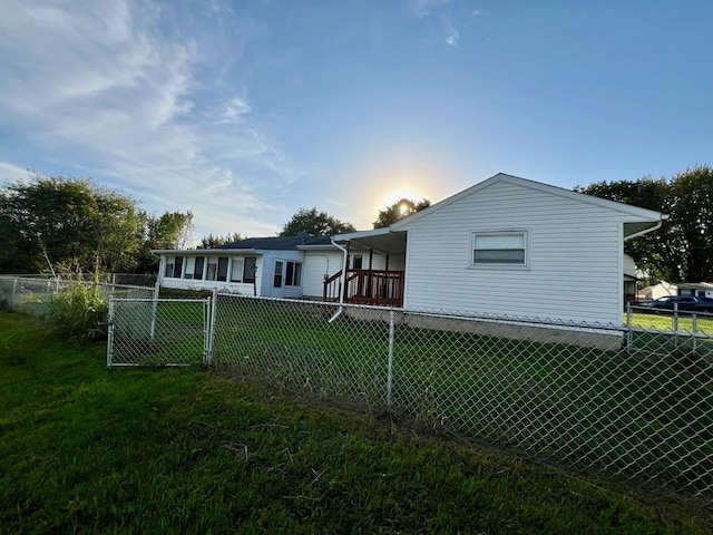 back house at dusk featuring a lawn