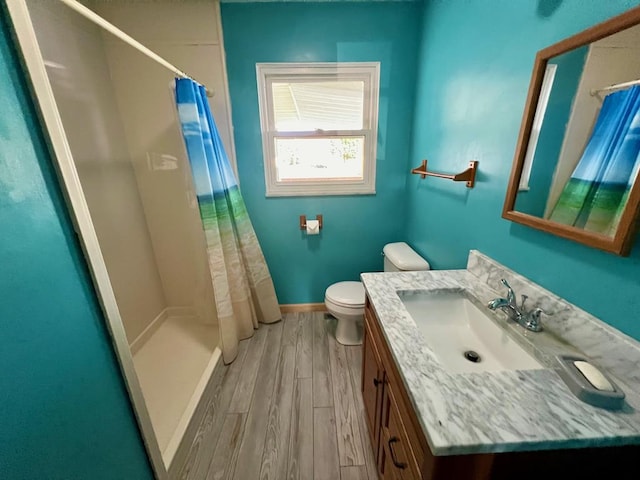 bathroom featuring hardwood / wood-style flooring, vanity, toilet, and a shower with curtain