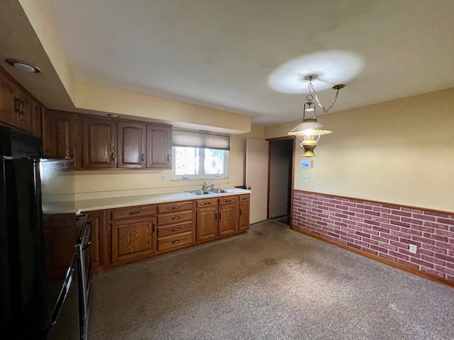 kitchen featuring black fridge, sink, decorative light fixtures, carpet floors, and brick wall