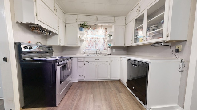 12 W Park Dr, Shelby, OH 44875 - kitchen with stainless steel range with electric cooktop, black dishwasher, light wood finished floors, light countertops, and white cabinets