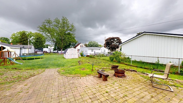 12 W Park Dr, Shelby, OH 44875 - view of patio / terrace with a fire pit, a trampoline, a playground, and a residential view