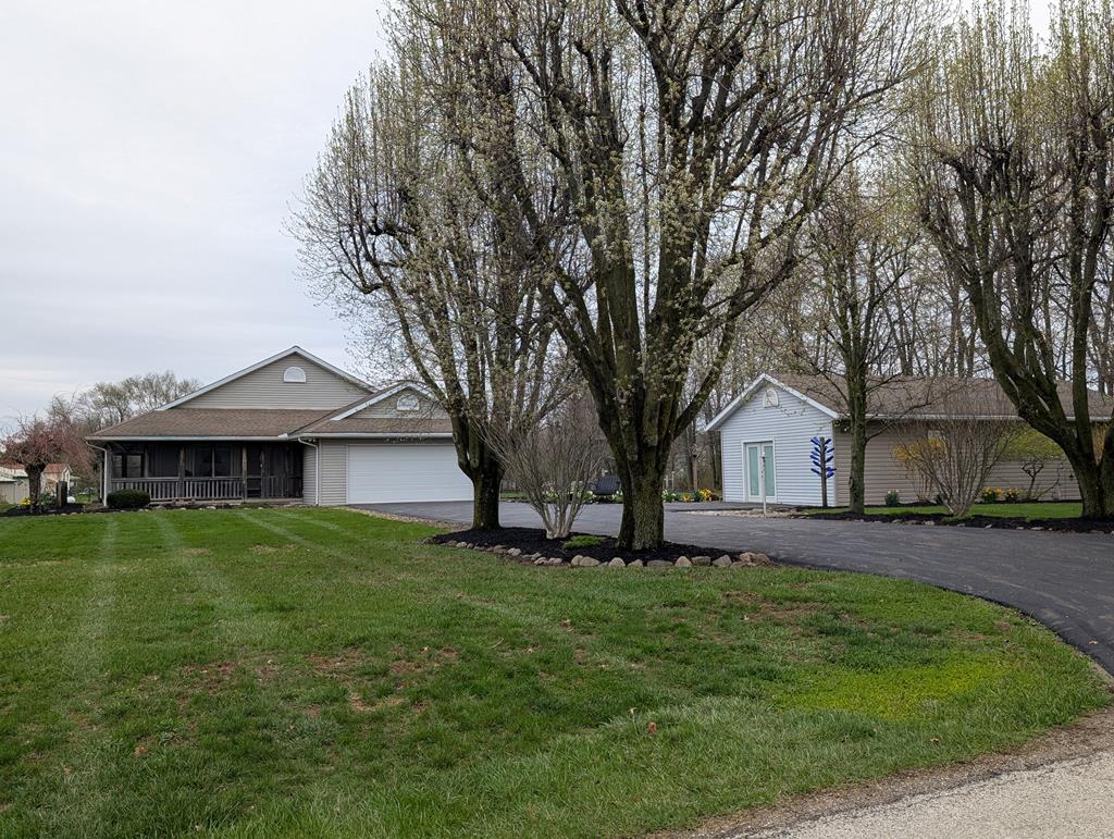 ranch-style home with a front lawn, a garage, and aphalt driveway