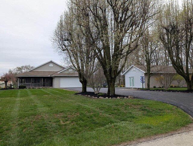 ranch-style home with a front lawn, a garage, and aphalt driveway