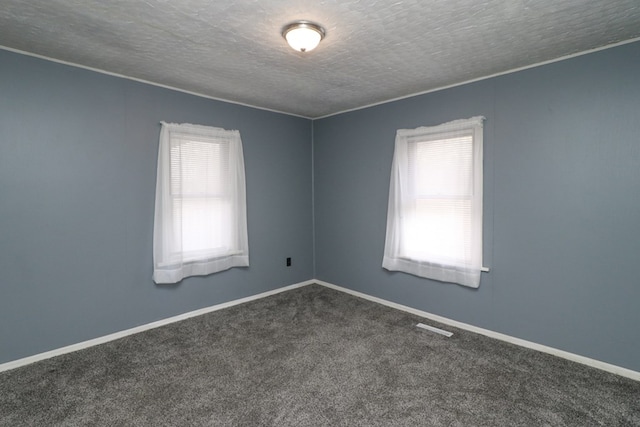 carpeted empty room featuring a textured ceiling