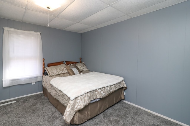 bedroom featuring dark colored carpet and a drop ceiling