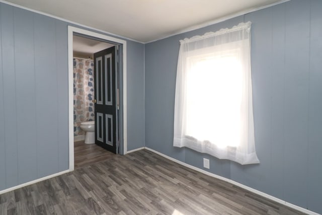 empty room with dark hardwood / wood-style flooring and a healthy amount of sunlight