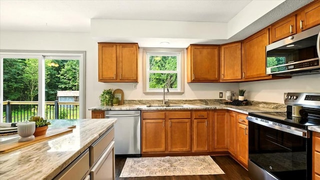 3306 Township Rd Unit 221, Marengo, OH 43334 - kitchen featuring appliances with stainless steel finishes, dark wood-style floors, light stone counters, and brown cabinets