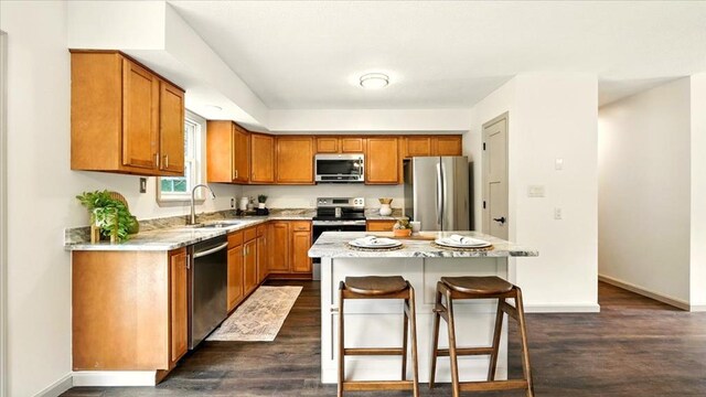 3306 Township Rd Unit 221, Marengo, OH 43334 - kitchen featuring stainless steel appliances, a kitchen bar, dark wood finished floors, and brown cabinetry