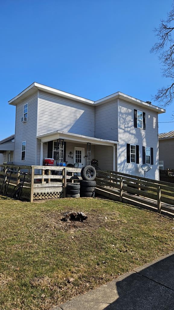 view of front of property featuring a front yard, a wooden deck, and fence