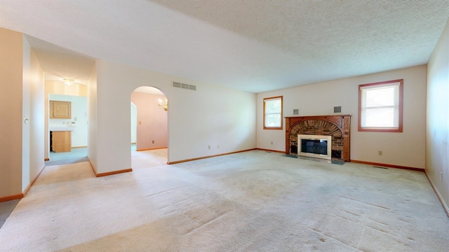 621 Heidi Ln, Mansfield, OH 44904 - unfurnished living room with arched walkways, plenty of natural light, a brick fireplace, and light carpet