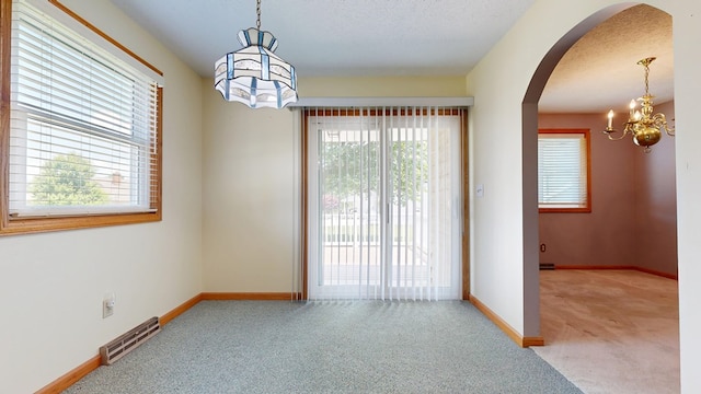 621 Heidi Ln, Mansfield, OH 44904 - unfurnished room featuring arched walkways, carpet floors, a chandelier, and a textured ceiling