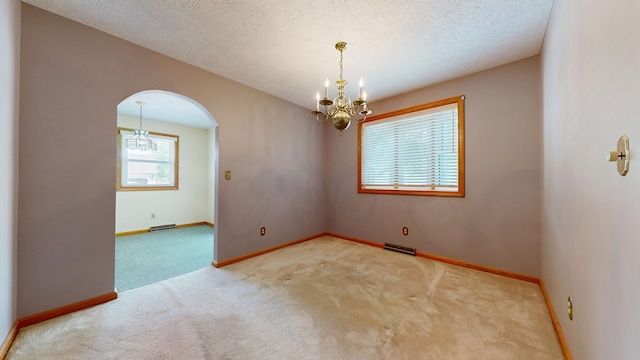 621 Heidi Ln, Mansfield, OH 44904 - carpeted spare room with arched walkways, a chandelier, and a textured ceiling