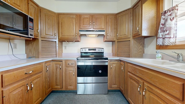 621 Heidi Ln, Mansfield, OH 44904 - kitchen with stainless steel range with electric cooktop, light countertops, under cabinet range hood, and brown cabinets