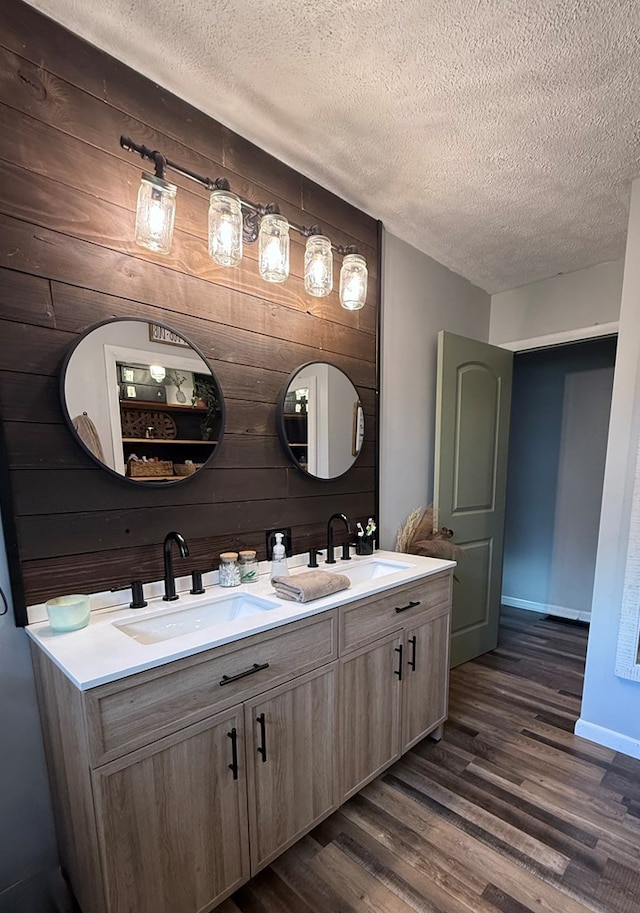 108 Melcher Blvd, Bucyrus, OH 44820 - full bathroom featuring double vanity, a textured ceiling, wood finished floors, wood walls, and baseboards